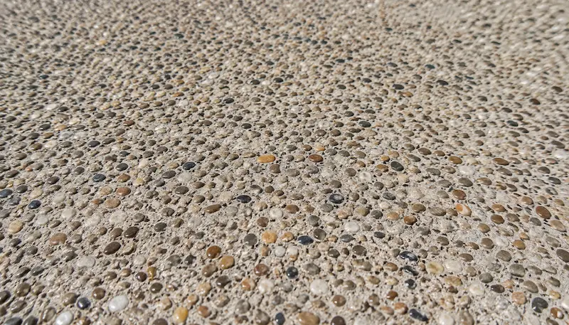 Gros plan sur une finition en béton désactivé avec granulats apparents