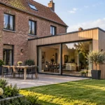 Idée extension maison : les solutions pour agrandir son espace de vie Maison en brique avec extension contemporaine en bois à toit plat et grandes baies vitrées donnant sur le jardin.